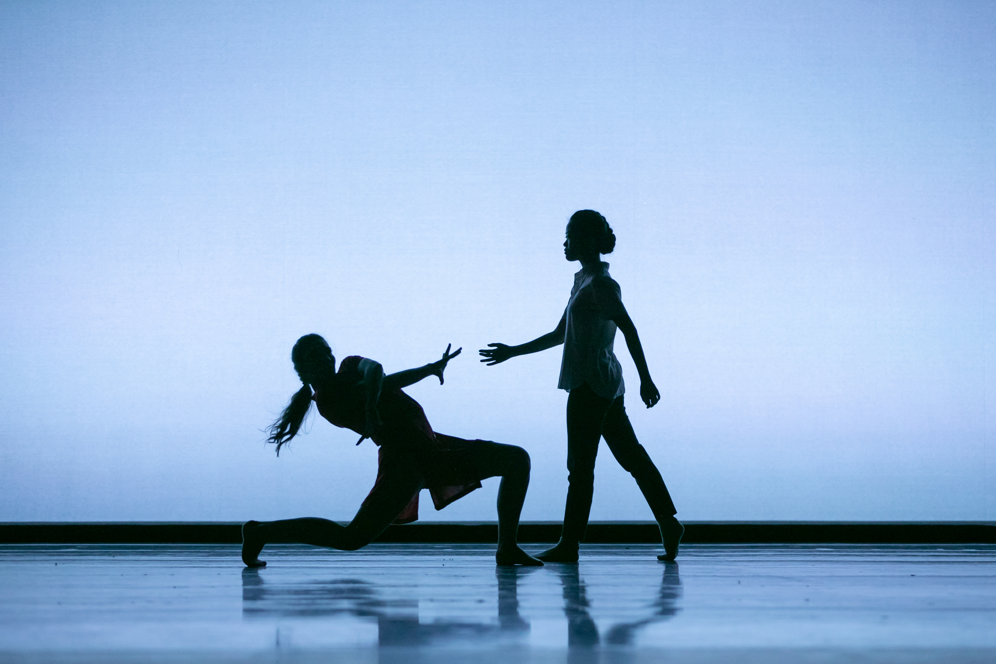 Two PNB School students dance in silhouette against a blue-grey backdrop in Amanda Morgan's Pages. Photo © Lindsay Thomas